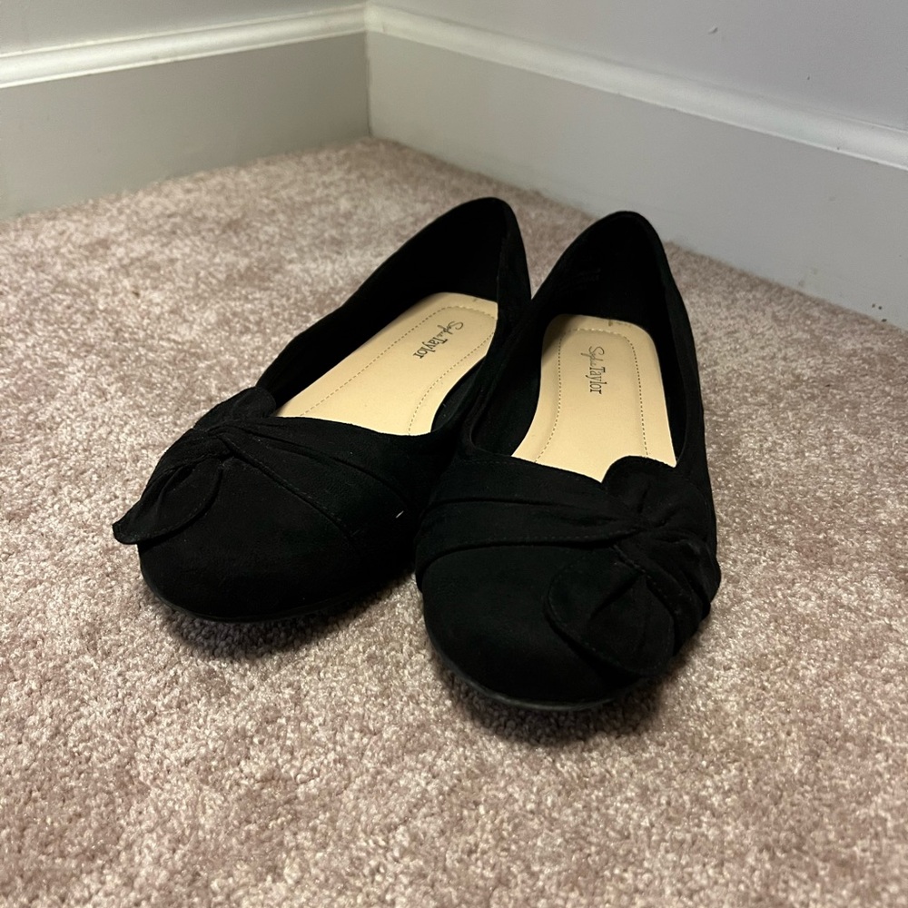 Black ballet flat type shoes with bow detail on toes.